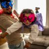 Dad and daughter wearing superhero masks playing games