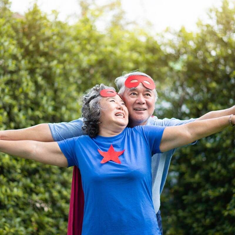 Superhero couple in retirement holding hands