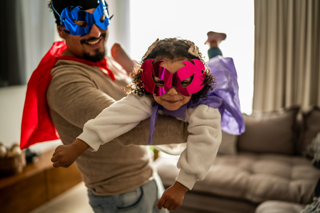Father and daughter pretending to be superheroes.